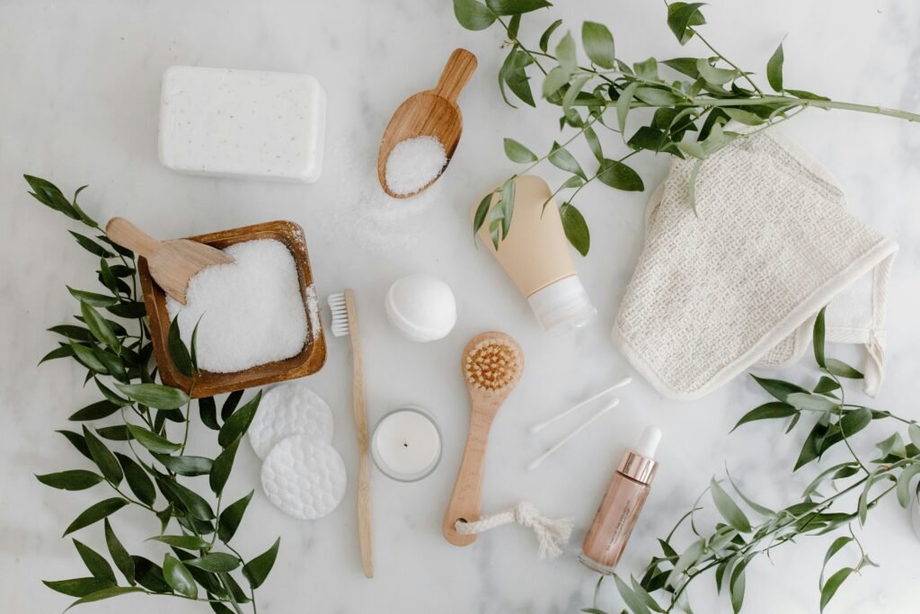 pexels-photo-6690884-6690884 Elegant flat lay of organic bath essentials including soap, brush, and salts with greenery.